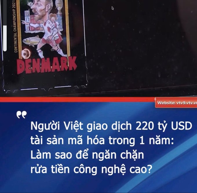 A Vietnamese news broadcast graphic shows a soccer card with 'DENMARK' written on it, along with the headline text 'Người Việt giao dịch 220 tỷ USD tài sản mã hóa trong 1 năm: Làm sao để ngăn chặn rửa tiền công nghệ cao?'