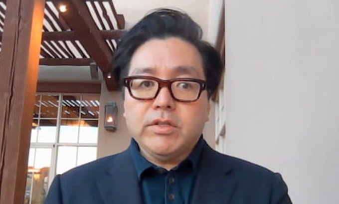 Tom Lee, Chairman of BitMine, appears in a video interview wearing a navy blazer and dark-rimmed glasses, discussing his bullish 10-year outlook on Ethereum's dominance in tokenization and AI chain infrastructure.