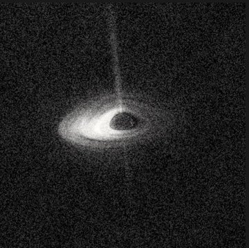 A grainy black-and-white astronomical image showing a bright celestial object with a dark shadow at its center and a faint vertical jet of material emanating upward, set against a star-filled background.