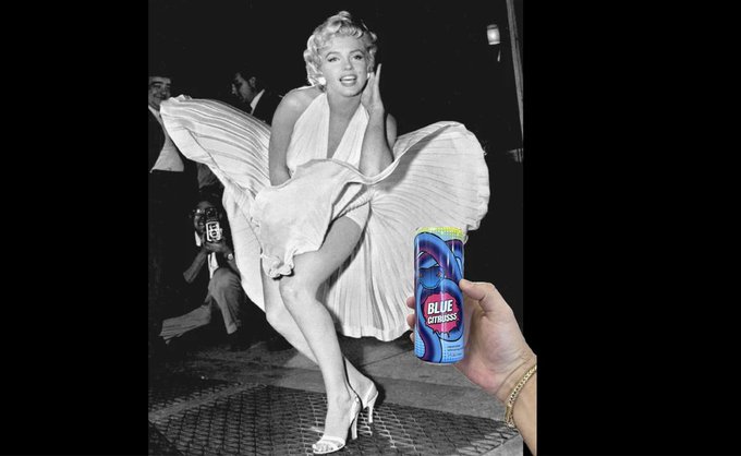 A black-and-white photo of Marilyn Monroe in her iconic billowing white dress pose, with a hand in the foreground holding a can of 'BLUE FITNESS' drink.