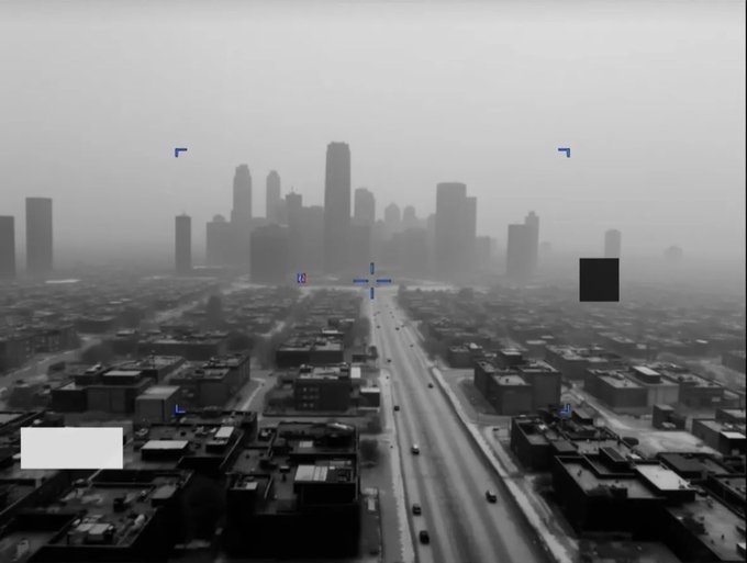 A grayscale aerial view of a foggy city skyline with downtown skyscrapers in the distance, overlaid with camera viewfinder brackets and a black censored box.
