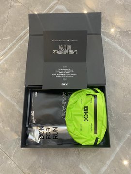 An unboxed OKX gift package contains a black card, neon green drawstring bag, and 'HAPPY NEW LUNA NEW YEAR' card with Chinese text reading '每月跑 不為何而跑行'.