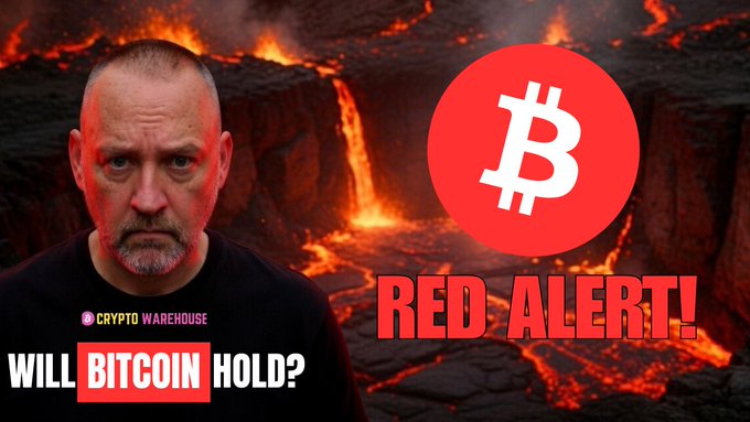 The image features a man wearing a black shirt with a red Bitcoin logo on it. The background of the image shows a lava flow, indicating that they are discussing cryptocurrency or Bitcoin. The caption below the image reads "Red Alert! Will Bitcoin hold?" which suggests that there is some concern about the stability and future value of Bitcoin.