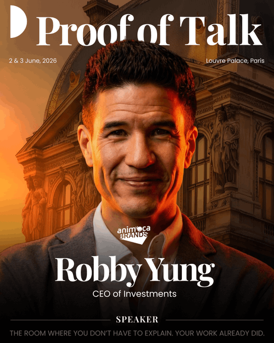 The image features a man wearing a suit and tie, smiling for the camera with his head tilted slightly to the left side. The background includes an old building or palace, suggesting that this photo was taken at a location where historical architecture can be found. The caption of the image reads "Speaker Robby Yung @viewfromhk", indicating that he is speaking at an event in Paris.