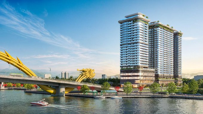 The image features a large building with two stories situated next to a river. The building has a modern design and appears to be made of glass, giving it an elegant appearance. A boat can be seen passing by on the water below the bridge. In addition to the main building, there is another smaller structure located further down the riverbank. The image also includes text that reads "Major news coming out of Vietnam for @hedera ระมายงสมีกลานิรถ้อง", which is likely a description or caption about the building and its location.
