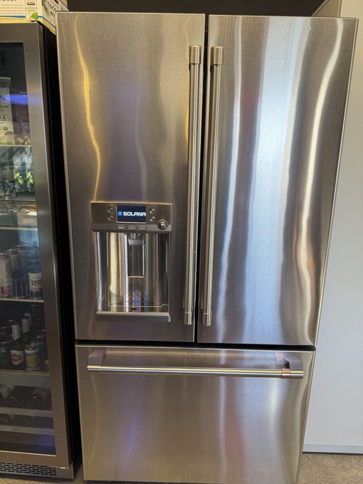 A stainless steel Solana French-door refrigerator with a water and ice dispenser on the left door and a bottom freezer drawer.
