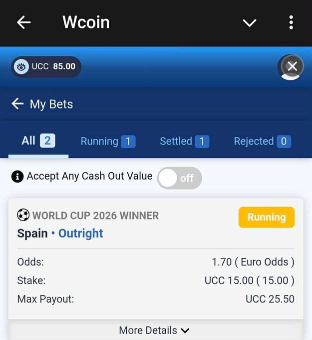 A sports betting app screen for Wcoin showing 'My Bets' with 2 total bets (1 Running, 1 Settled, 0 Rejected), featuring an active World Cup 2026 Winner bet on Spain Outright at 1.70 odds with a 15.00 UCC stake.
