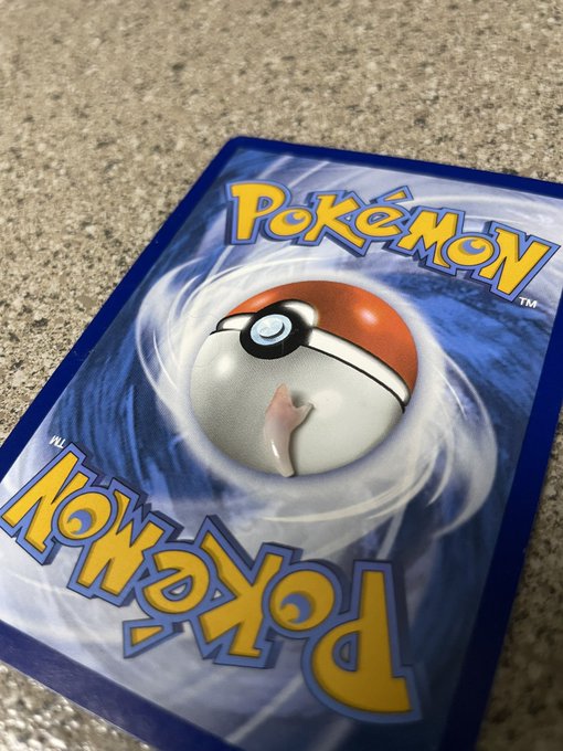 The back of a Pokémon trading card game binder or box with the classic Pokémon logo and Poké Ball design on a blue background.