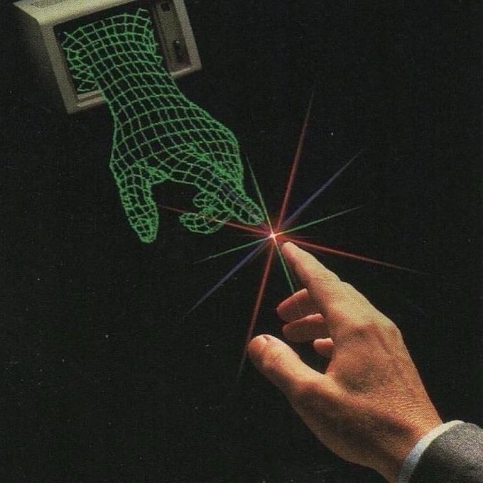 Vintage sci-fi illustration of a human hand reaching toward a laser light, with a wireframe holographic hand emerging from a computer terminal, symbolizing early virtual reality or human-computer interaction concepts.