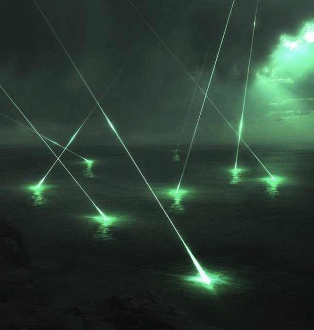 An otherworldly nighttime seascape features multiple bright green laser-like beams of light striking the ocean surface from the cloudy sky above.