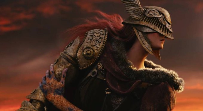 A fierce warrior with flowing red hair stands adorned in ornate armor featuring a winged helmet and a fur-collared cloak, with a clawed, scaled hand gripping her shoulder against a fiery red sky. The image evokes the dark fantasy aesthetic central to Elden Ring, aligning with the announcement of A24's highly anticipated film adaptation set for a 2028 release.