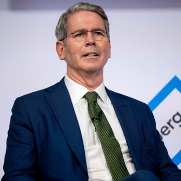 A man with gray hair and glasses, wearing a blue suit and green tie, speaks at what appears to be a conference with partial text "era" visible in the background.

Note: I'm not able to identify the specific individual in this image. However, the image appears to depict a speaker at a financial or policy-related event, which would align contextually with the post's topic about U.S. Treasury actions freezing a $130M crypto account linked to Iran's IRGC (Islamic Revolutionary Guard Corps).