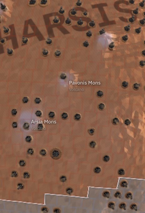 A topographical map of a reddish planetary surface, likely Mars, labeled with 'Pavonis Mons Volcano' and 'Arsia Mons Volcano', featuring numerous dark crater-like spots.