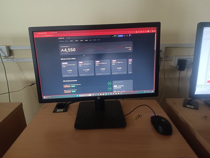 An HP monitor on a wooden desk displays an Adobe analytics dashboard showing 'A4,550' and tier progression cards ('Become The First Link Order A250', 'Sign in 25 Days in A A1,000', 'Sign in 15 Days in A A500', 'Sign in 7 Days in A A350'). A black Logitech mouse is on the desk beside it.