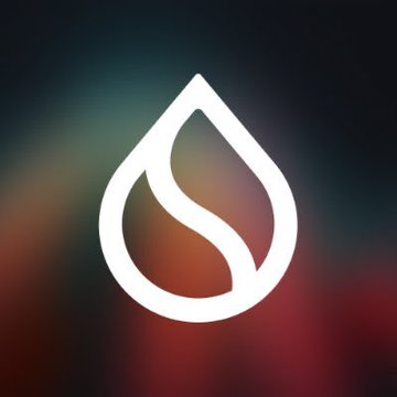 A white stylized leaf or flame logo centered on a blurred dark background with colorful gradients.