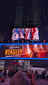 Night scene of Times Square featuring a large billboard advertising 'NEAGLEY' described as 'FROM EXECUTIVE PRODUCER JASON BATEMAN A PRIME ORIGINAL' with Amazon branding visible