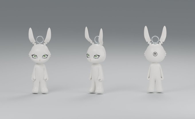 Three angles of a white rabbit-eared designer figure with green eyes are shown, with the back view revealing an "M" logo on its head, presented as a sculptural collectible that aligns with the post's emphasis on its striking visual appeal.