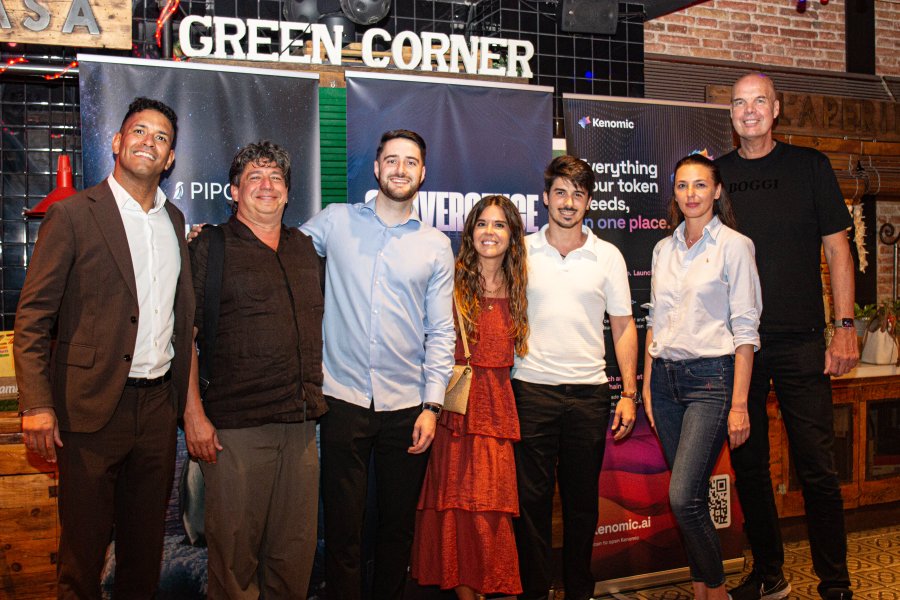 Seven people pose together at "Convergence Barcelona," standing in front of banners displaying "GREEN CORNER," "PIPG," "AVERCHANGE," and "Kenomic," capturing the networking and collaboration that defined the 6th edition of the event.