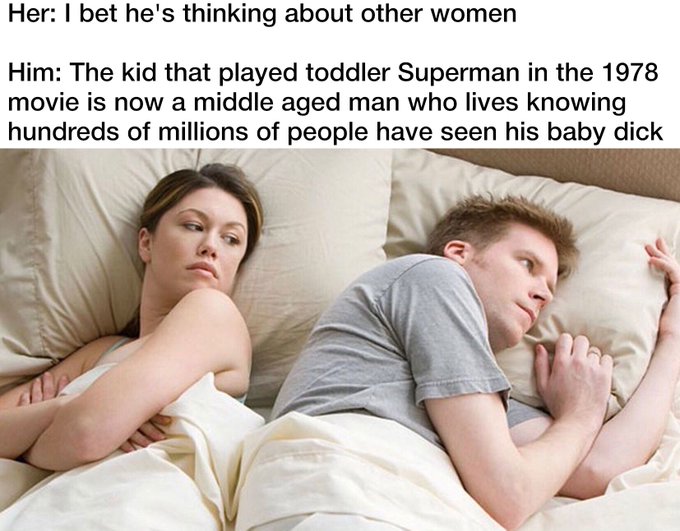 Meme with text 'Her: I bet he's thinking about other women / Him: The kid that played toddler Superman in the 1978 movie is now a middle aged man who lives knowing hundreds of millions of people have seen his baby dick', showing a couple in bed facing away from each other.