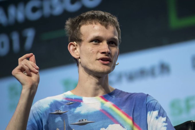 Vitalik Buterin, Ethereum co-founder, speaks at a Cisco event (visible 'cisco' and '017' text in background) while wearing a colorful t-shirt featuring UFOs and rainbows.
