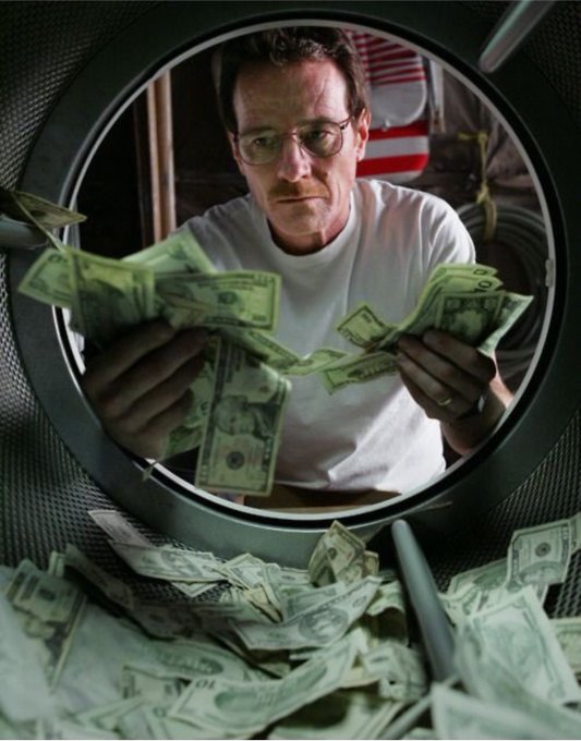 A man in glasses counting cash inside what appears to be a front-loading washing machine drum filled with money.