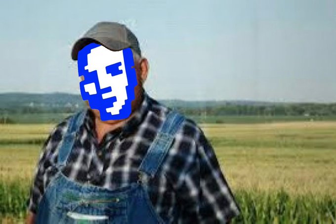 A person in overalls and a plaid shirt stands in a field, with their face obscured by a pixelated blue skull-like avatar.