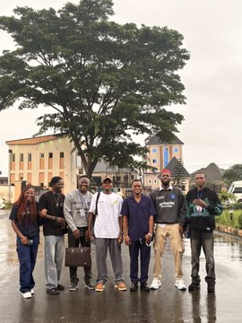 A group of eight people pose together in front of a large tree and a light-colored building, smiling for a photo that captures the camaraderie mentioned in the post about meeting amazing people at #AWDEC. The attendees, tagged with handles like @Web3Goddezz, @BTC_AMB, and @eke_gg, gather on a wet street, embodying the spirit of the post's message: "create your own fun."