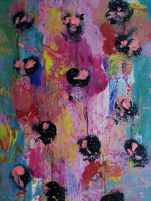 A vibrant, expressive mixed-media painting featuring black flower-like shapes with pink centers scattered across a richly textured background of pink, yellow, blue, and green brushstrokes.