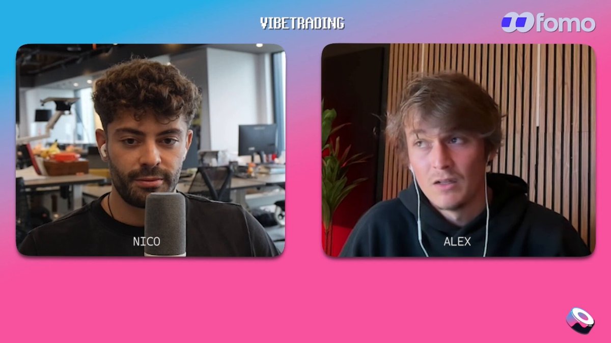 The image shows two men sitting across from each other at a desk with microphones, appearing to be having a conversation or participating in an interview. The background features a pink wall that has the words "Vibetting" written on it. There is also text that reads "Focus on what is in the image and how it relates to the post".