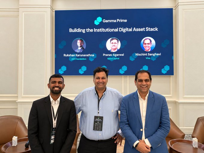 Three men pose in front of a screen titled "Building the Institutional Digital Asset Stack" at the Gamma Summit, featuring Rukshan Karunaratna (ADI Foundation), Pranav Agarwal (Aliya Capital), and Nischint Sanghavi (Visa), with the leftmost and rightmost individuals corresponding to the panelists named in the accompanying post.