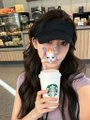 The image features a woman with long hair holding a Starbucks coffee cup, wearing a black hat or visor. The photo also includes text that reads "Crypto Survival Plan-Day 8 Bitget Wallet U卡使用一周啦日常点外卖线上线下购物基本都用了卡点", which seems to be a reference to Bitcoin or cryptocurrency.
The woman is wearing a black hat, and the Starbucks cup she's holding has a white lid with a green logo on it. The image also contains text that reads "Crypto Survival Plan-Day 8 Bitget Wallet U卡使用一周啦日常点外卖线上线下购物基本都用了卡点", which might be a reference to Bitcoin or another cryptocurrency.