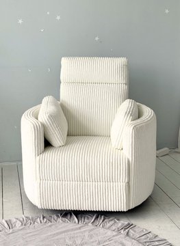 A cream-colored corduroy armchair with two small matching pillows sits against a gray wall decorated with star stickers.