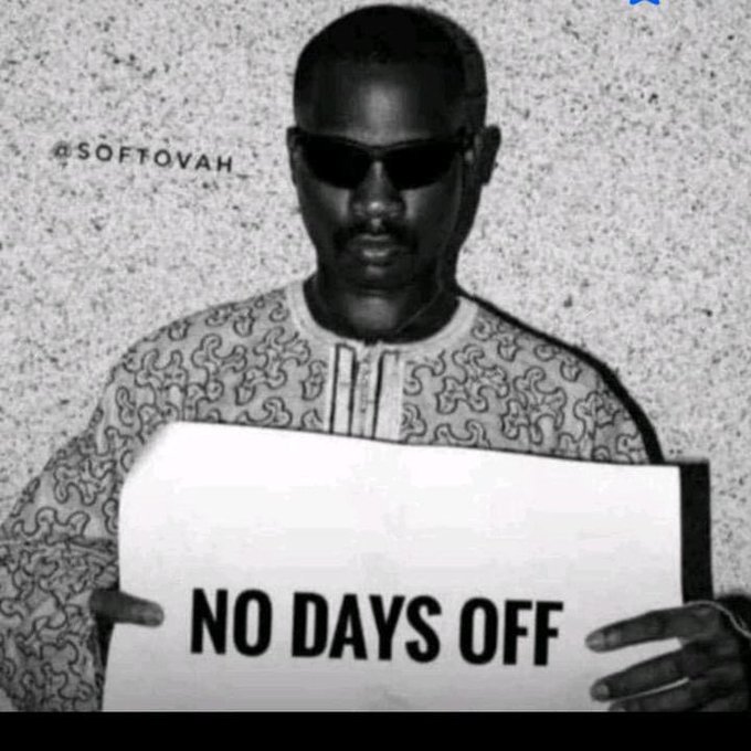 A black-and-white photo of a man wearing sunglasses holding a sign that reads 'NO DAYS OFF', credited to @SOTOVAH.