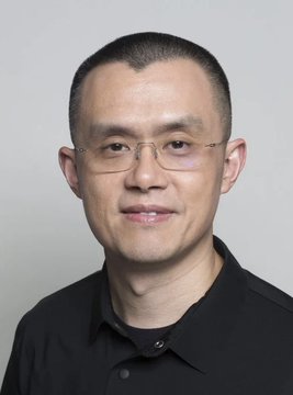 A headshot of CZ (Changpeng Zhao), the founder of Binance, smiling slightly while wearing glasses and a black polo shirt. The image accompanies news that CZ stated he personally holds no memecoins, with his portfolio consisting almost entirely of Bitcoin and BNB.