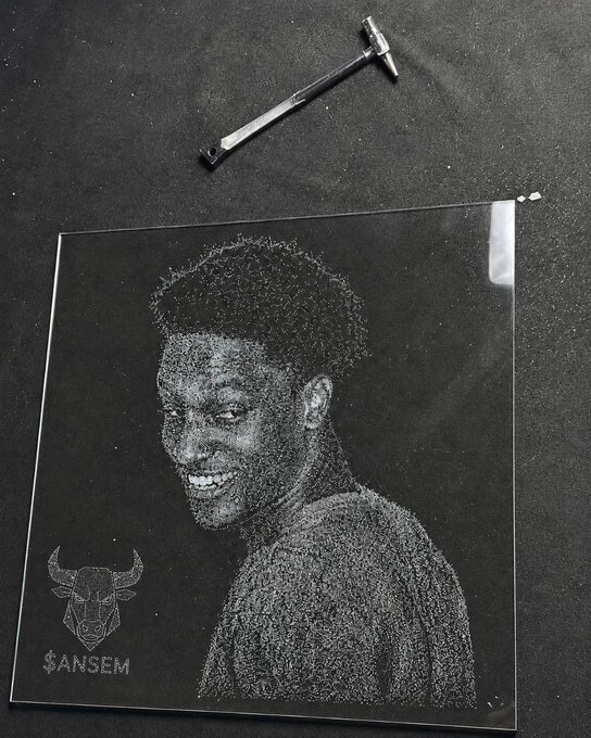 A scratched/engraved glass or acrylic portrait of a smiling young man with the Chicago Bulls logo and '$ANSEM' text, photographed in black and white with a small hammer at the top.