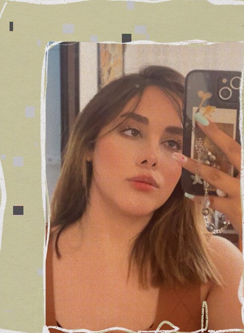 A selfie-style portrait of a young woman with brown hair taking a mirror photo with a smartphone, with the image presented in a torn paper frame effect.