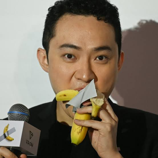 Justin Sun, founder of TRON, biting into a banana on the Tron website.