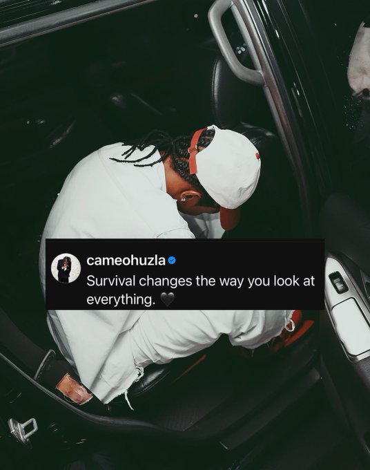 A person wearing white clothing and a red cap is curled up inside a car seat, overlaid with a tweet from "cameohuzla" that reads "Survival changes the way you look at everything."