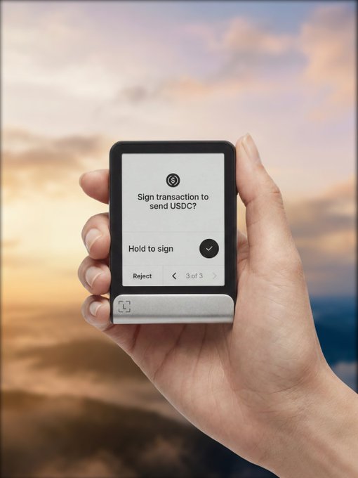 A hand holds a Ledger hardware wallet displaying a signing prompt for a USDC transaction, illustrating the post's message about securing USDC on Arc with Ledger Wallet™ by signing transactions directly on-device rather than relying on software wallets.