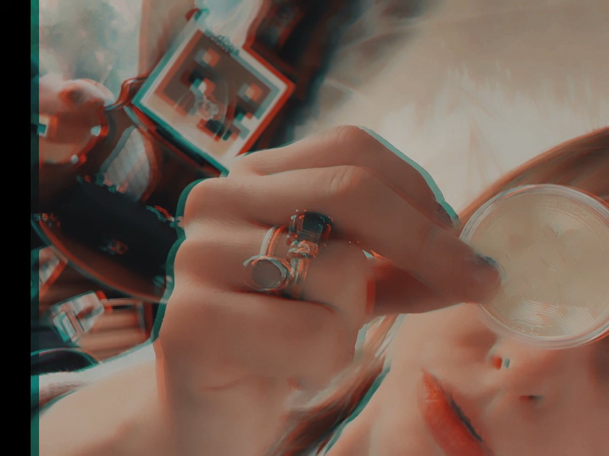 A stylized image with a red-cyan 3D effect showing a hand adorned with rings holding a coin near a blurred arcade or casino machine.