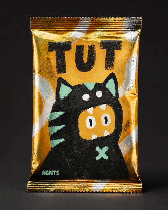A golden snack package with the text "TUT" featuring a black cat-like character wearing a tiger hood, branded "AGNTS" at the bottom.