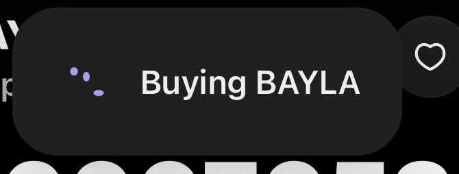 A dark interface displays a button labeled "Buying BAYLA" with a loading indicator, alongside a heart icon for favoriting. This visual represents an on-chain transaction being initiated to purchase the BAYLA token, consistent with the post's reference to time-stamped on-chain activity.