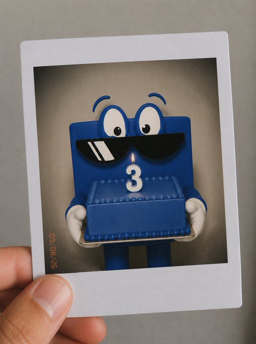 A polaroid photo dated '05/06/26' held by a hand showing a blue cartoonish figure with sunglasses holding a blue cake with a '3' candle.