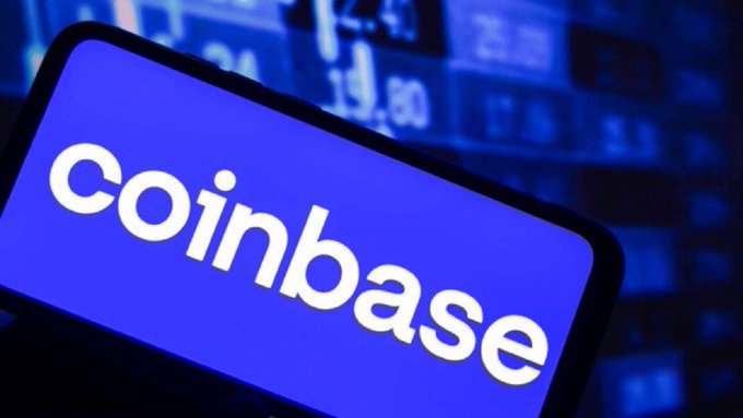 The image features a cell phone with the Coinbase logo displayed prominently on its screen, indicating that the device is likely used for cryptocurrency transactions or payments. The text "BIGGG COINBASE CALLS ON CONGRESS TO REMOVE TAXES FOR EVERYDAY #BITCOIN TRANSACTIONS THATS MASSIVE" suggests that Coinbase has recently made a significant announcement regarding tax relief for everyday users of their cryptocurrency platform, which could potentially impact the way people use and perceive Bitcoin.
