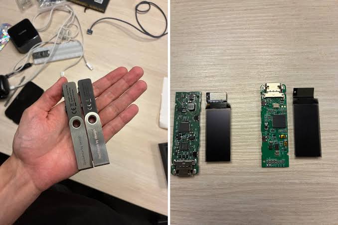 A hand holds two grey hardware security keys labeled 'YubiKey 5C NFC' and 'YubiKey 5C', with the right side showing their internal circuit boards and USB-C connectors laid out on a wooden surface.