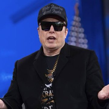 Elon Musk, wearing his signature "Make America Great Again" cap and sunglasses, speaks at a podium while a chain necklace hangs over his black jacket and graphic tee, captured in the context of his rumored endorsement of the memecoin $SLINK.