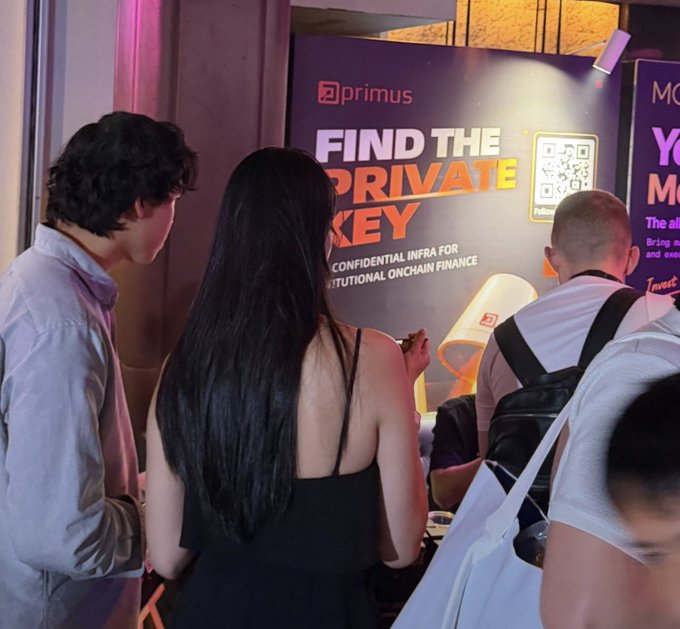 People gather near a promotional booth with a sign reading 'primus - FIND THE PRIVATE KEY - CONFIDENTIAL INFRA FOR INSTITUTIONAL ONCHAIN FINANCE' featuring a QR code.