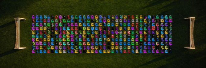 A top-down view of a large grid of colorful, low-poly mecha or robot vehicles arranged in neat formation between two barriers, with no visible text or numbers. The image relates to the post by showcasing a collection of NFT-style "degen projects" on Robinhood, possibly teasing a similar gathering or drop from the @netmachines_ project mentioned in the caption.