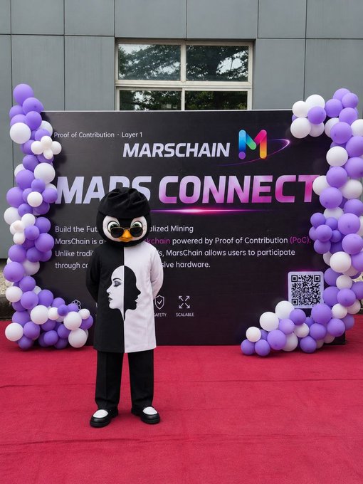 A person in a black-and-white penguin mascot costume standing on a red carpet in front of a 'MARS CONNECT' backdrop decorated with purple and white balloons, promoting MarsChain blockchain.