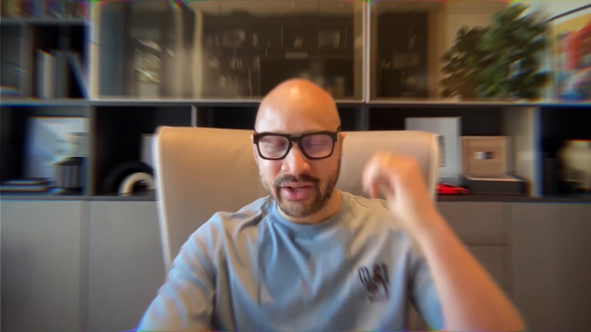 The image shows a man wearing glasses sitting in an office chair, with his hand raised as if he's about to make a point or gesture during a video call. The background features a bookshelf filled with various items such as books and plants, suggesting that this is likely taking place in an office setting. The caption of the image reads: " Users should own their data. Not Facebook. Not OpenAI. You." This message emphasizes the importance of individual ownership and control over personal information, which is a key aspect of decentralization efforts to combat surveillance and protect privacy.